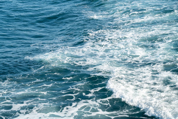 Stormy sea ocean, water surface with white foam and breaking waves.