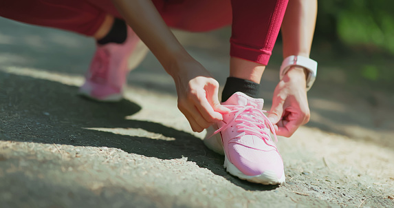 Closeup asian woman tie tight her shoelace before starting a run