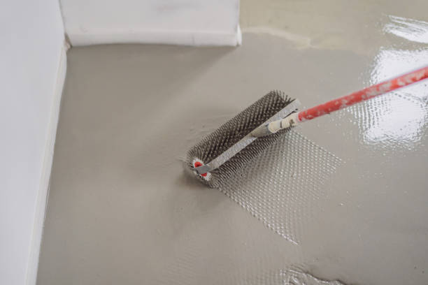 istock plasterer during floor covering works with self-levelling cement mortar, uses a needle roller 2090625289