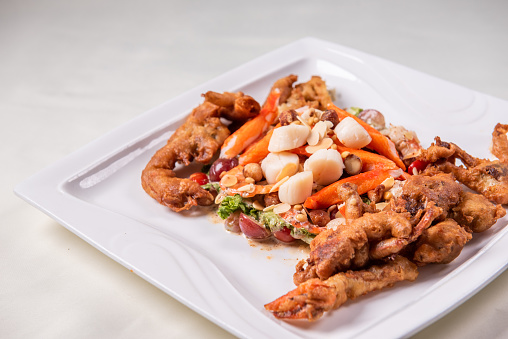 chinese and western mixed seafood combination cold platter with deep fried soft shell crab scallop salad on wood table asian restaurant banquet halal food cafe menu