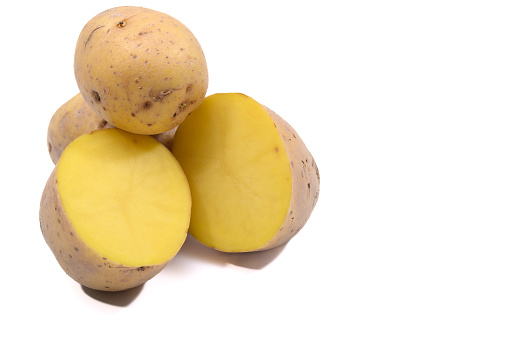 Isolated potatoes on a white background, whole and in cross-section, with yellow flesh