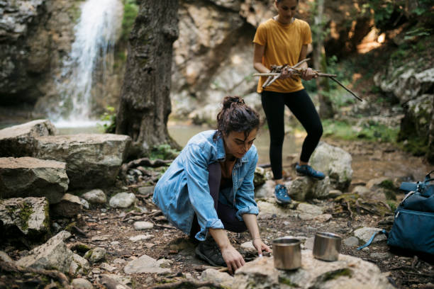 istock Women setting up campfire for cooking food on mountain hike 2090789522
