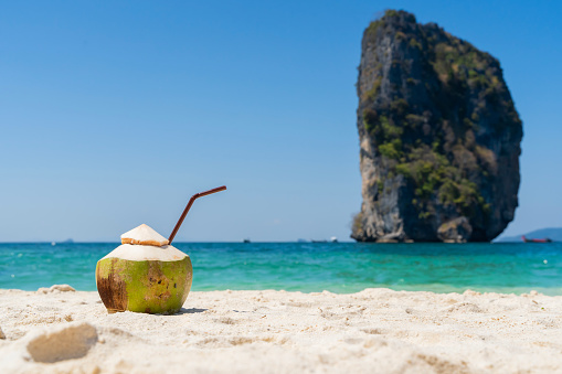 Relaxing on a tropical beach in Phuket, Thailand. Sipping on a refreshing coconut drink while enjoying the stunning views of the Andaman Sea. Soaking up the sun on the white-sand beaches of Phuket.