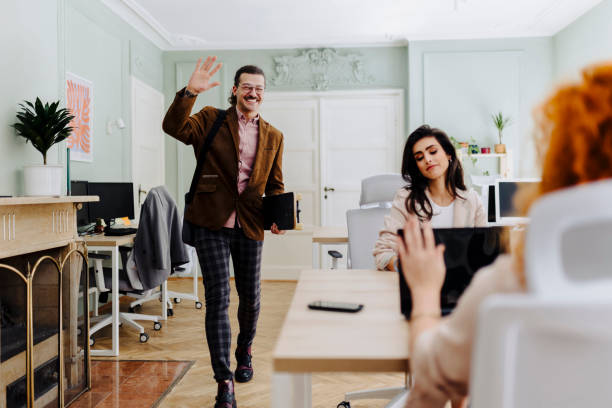 istock Happy businessman waving to someone while entering the office 2090793767