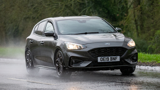 Milton Keynes,UK-Mar 17th 2024: 2019 grey Ford Focus car driving in the rain