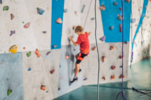 Child having fun exercising and playing outdoors climbing a green wall
