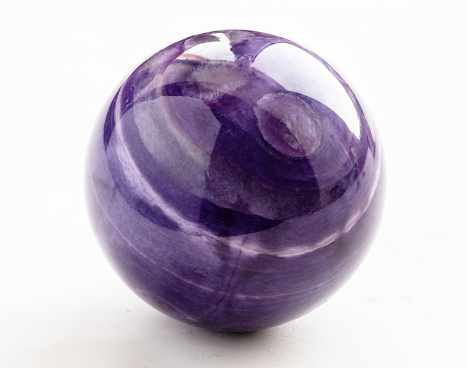 polished ball from natural charoite mineral on white background from Sakha Republic, Siberia, Russia