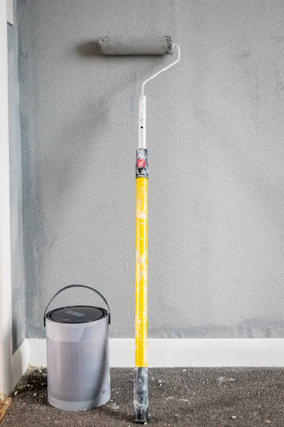 istock Paint roller extendable pole over painted woodchip wallpaper wall during home renovation in england uk 2090813827