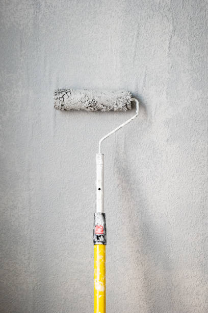 istock Paint roller extendable pole over painted woodchip wallpaper wall during home renovation in england uk 2090813840