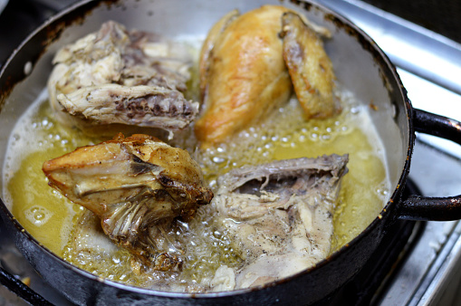 frying chicken quarters with skin and bones in deep oil, baking, grilling, barbecuing, frying ready to be served, white meat of chicken quarters in a plate, selective focus