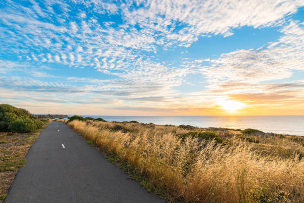 O'Sullivan Beach bicycle track along the shoreline with clouds over the sea during sunset, South Australia