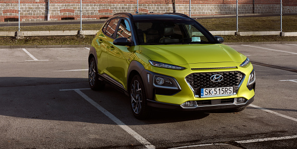 Hybrid Hyundai Kona parked next to an old brewery. It's an SUV on the platform of a city car, the total power of the gasoline engine and electric motor is 141 hp, Tychy, Poland-02.15.2020