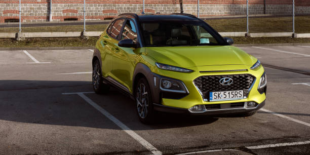 hybrid hyundai kona parked next to an old brewery. it's an suv on the platform of a city car, the total power of the gasoline engine and electric motor is 141 hp, tychy, poland-02.15.2020 - hyundai стоковые фото и изображения