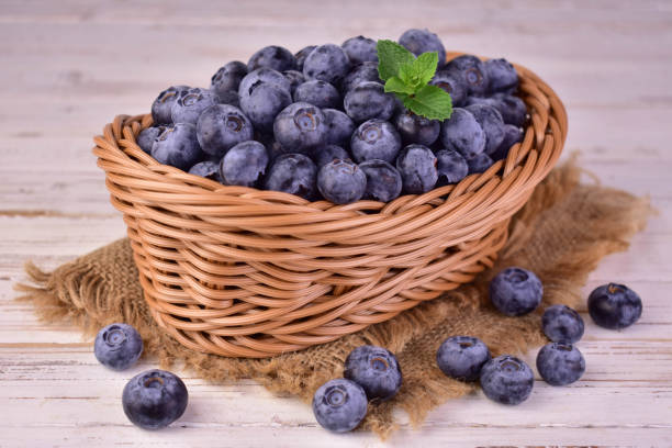 istock Blueberries in a basket on a wooden background. Close-up. 2091025262