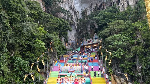 Batu Caves, a limestone cave that is more than 400 million years old, is a sacred place amidst mountains with colorful stairs and statues of Hindu gods.