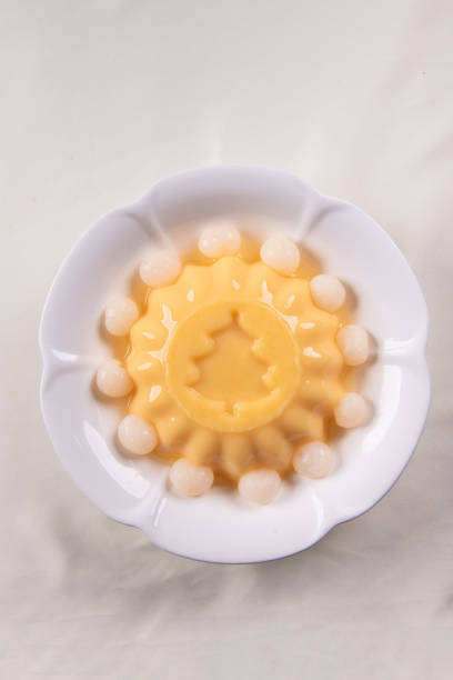 ice cold cute yellow mango fruit pudding big xmas tree mould jelly in plate with longan fruit decor on wood table asian cafe sweet kids dessert halal food restaurant menu