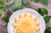 ice cold cute yellow mango fruit pudding big xmas tree mould jelly in plate with longan fruit decor on wood table asian cafe sweet kids dessert halal food restaurant menu