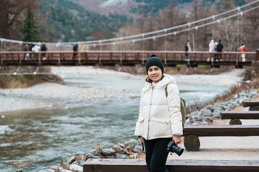 Woman tourist travel Kamikochi National Park, happy Traveler sightseeing Kappa bashi bridge, Nagano Prefecture, Japan. Landmark for tourists attraction. Japan Travel, Destination and Vacation concept