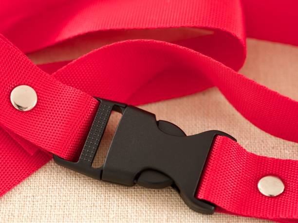istock A black contoured side release plastic buckle with red nylon belt on a beige textile background 2091243981