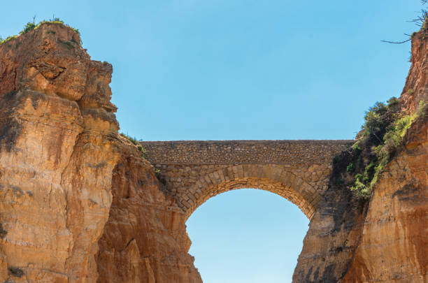 Detailed View of arched bridge with sailboat in Students Beach in Lagos, Algarve, Portugal