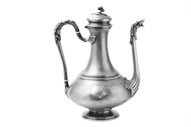 Antique metal vessel with spout and handle isolated on a white background. Vintage silver jug lamp teapot. East tableware.
