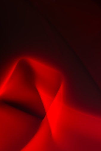 Abstract red smoke and light on a black background with smooth lines. Copy space. Design element.