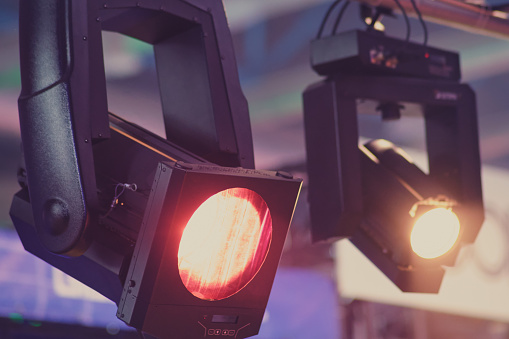 Stage lights on a red background. The stage is illuminated by the spotlight.