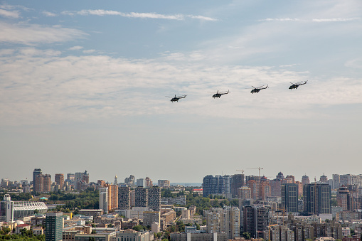 Kyiv, Ukraine - August 22., 2021: Aerial summer cityscape with flying military helicopters MI-8 during parade dedicated to Independence Day of Ukraine.