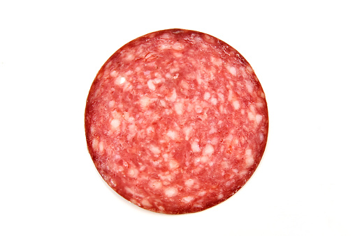 Sausage salami round piece on white background isolated. Raw smoked sausage with lard for sandwich