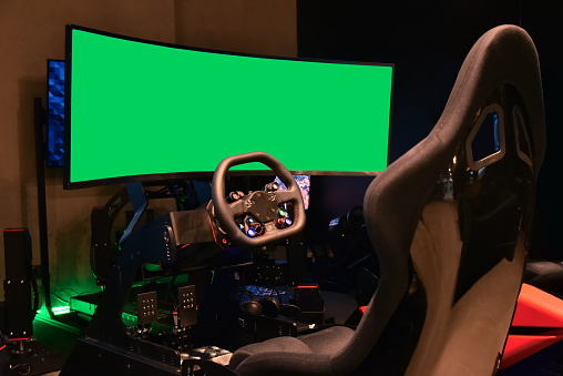 Simulator of race car driver with panoramic monitor with green screen for inserting your design and installation. Professional simulator seat place online car racing game.