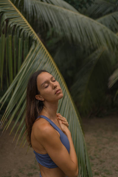 istock Young woman preforms breathing exercises outdoors 2091354598