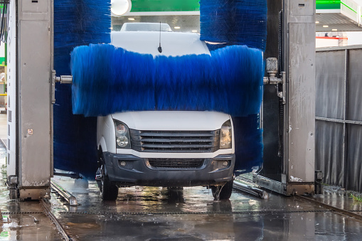 Automatic wash blue brush rotate in action, white mini vancar comes out ready clean.