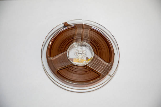 Close up on an old school audio reel to reel tape against a white background .
