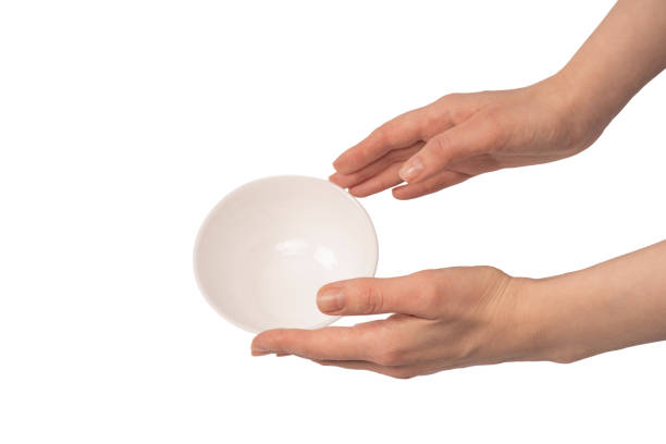 istock Female hand is holding a ceramic bowl isolated on white background. 2091375415