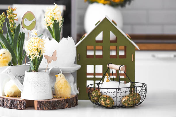 istock Happy Easter. Spring yellow hyacinth flowers in an egg-shaped vase, chicken chicks on a white table. In the background is a white Scandinavian-style kitchen. Easter decor in the house. 2091375980