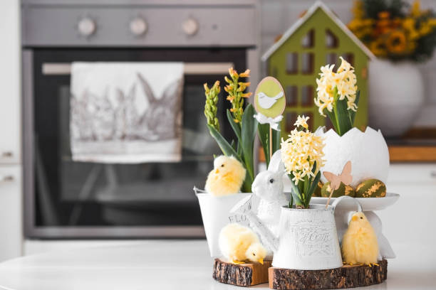 istock Happy Easter. Spring yellow hyacinth flowers in an egg-shaped vase, chicken chicks on a white table. In the background is a white Scandinavian-style kitchen. Easter decor in the house. 2091375981