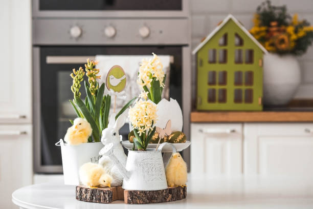 istock Happy Easter. Spring yellow hyacinth flowers in an egg-shaped vase, chicken chicks on a white table. In the background is a white Scandinavian-style kitchen. Easter decor in the house. 2091375989
