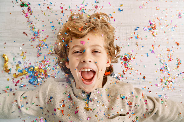 istock Excited little boy screaming joyfully covered with confetti 2091405401