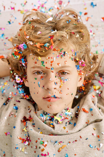 istock Fair haired kid with confetti on face and clothes 2091407478