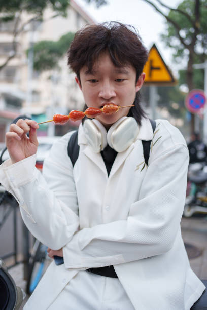 istock Young man eating candied haws 2091431943