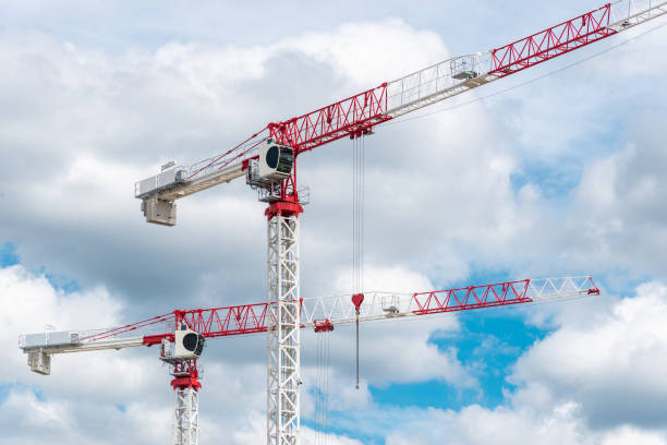 istock Two construction cranes against blue sky at sunny day 2091475509