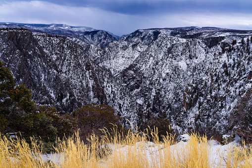 Black Canyon of the Gunnison with Fresh Snow - Scenic winter landscape of dark canyon views from South Rim of canyon. Rugged canyon after fresh snow storm.