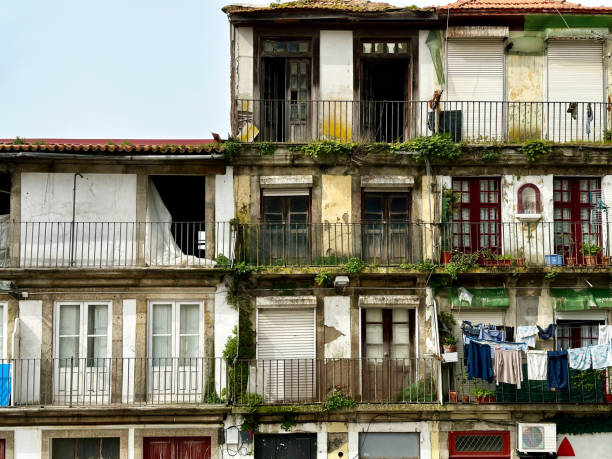 Other view on Porto, Portugal. Very old house in the city center. Poverty and devastation. Old, abandoned houses with orange tiled roofs. Ruined and almost collapsing residential buildings.