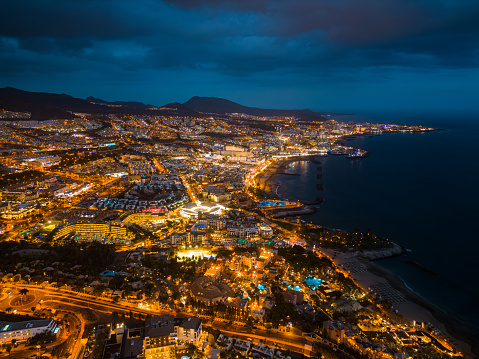 illuminated night city light view, beautiful ocean shore, Tenerife, Canary island aerial. High quality photo