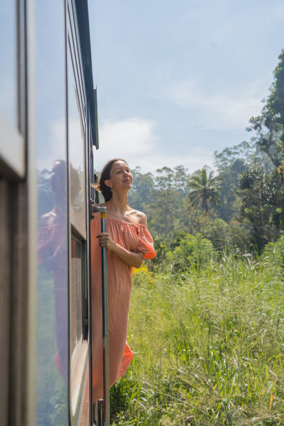 istock Young woman travels on train through rainforest 2091506129