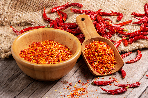 Cayenne peppers in a wooden bowl, dried chili peppers and red paprika, spicy, healthy food, top view
