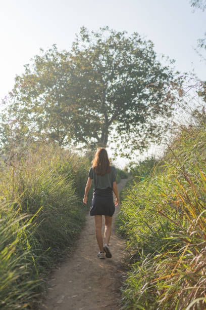 istock Young woman hikes up path through lush meadow 2091509301