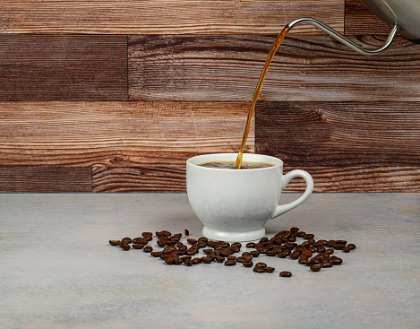 Pouring coffee - roasted coffee beans on table