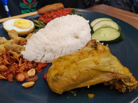 Fried Chicken Breast Rice With Eggs Sliced, Cucumber Sliced, Long Bean, Spicy Peanut And Chili Sauce. Nasi Ayam Goreng Dada. Food Menu.