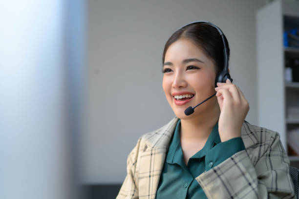 istock A woman wearing a headset is smiling while talking on the phone 2091590293